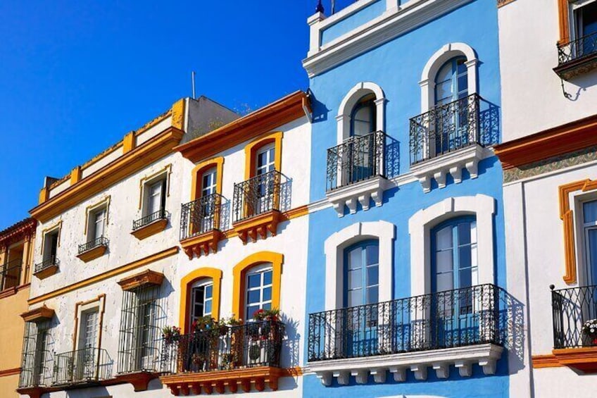 A row of colorful buildings with balconies and windows. 4