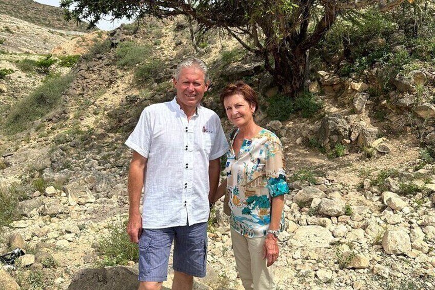 Dos personas de pie en una ladera rocosa con vegetación escasa. 4