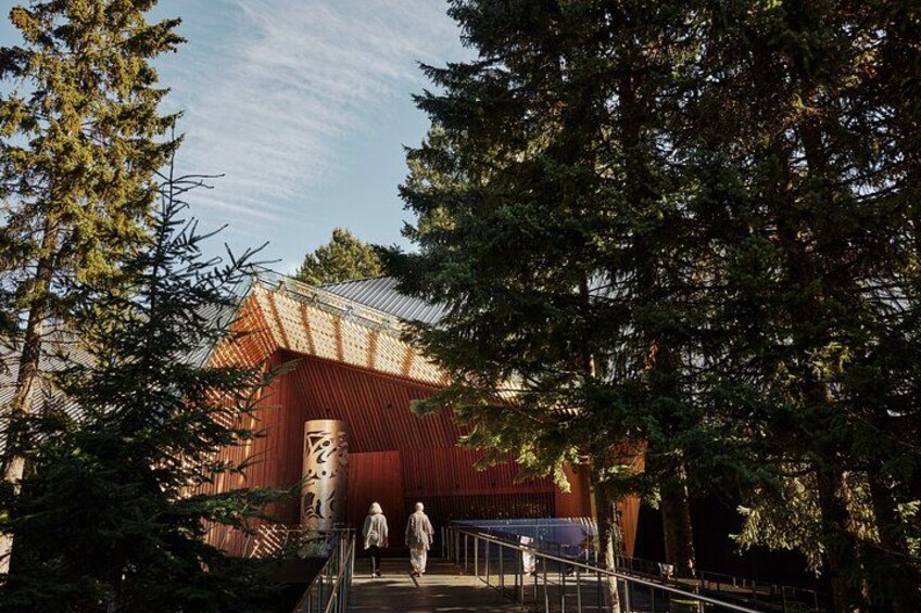 A red building with a metal roof, surrounded by trees. 2