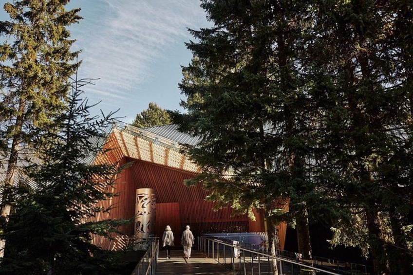 A red building with a metal roof, surrounded by trees. 4