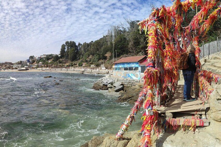 A coastal scene with a wooden walkway, colorful ribbons, and a person standing on the path. 2