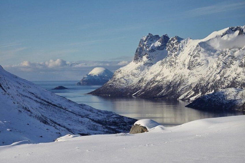 Paisaje montañoso nevado con un lago y cielos despejados. 1