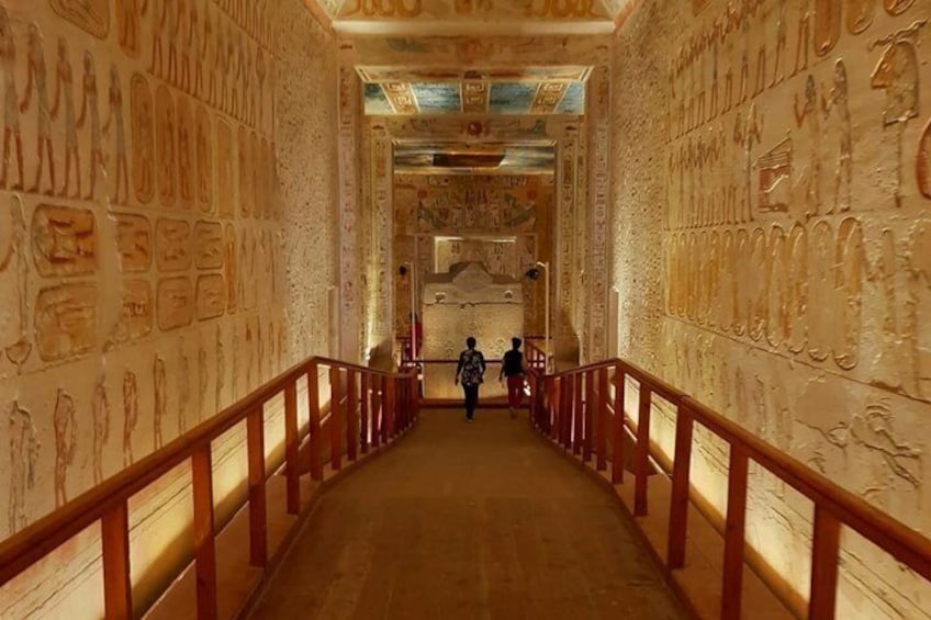 A corridor with hieroglyphs on the walls and a wooden railing. 2