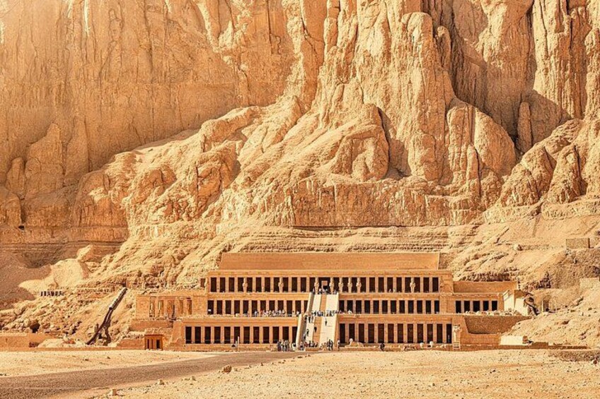 A large ancient Egyptian temple complex with towering cliffs in the background. 4