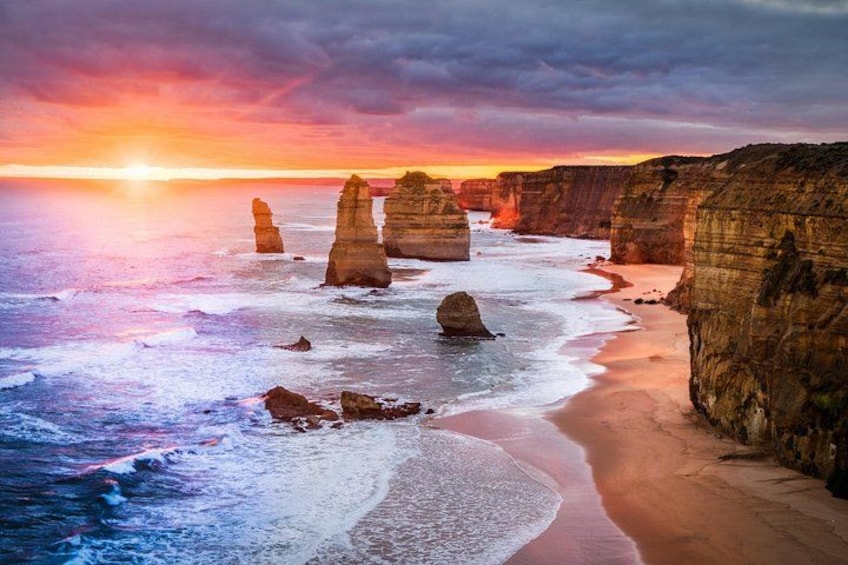 A coastal landscape with prominent rock formations and a sunset. 1