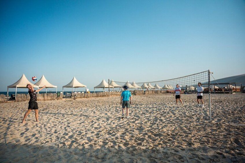Ein Beachvolleyballspiel mit Zelten und einem Netz. 3