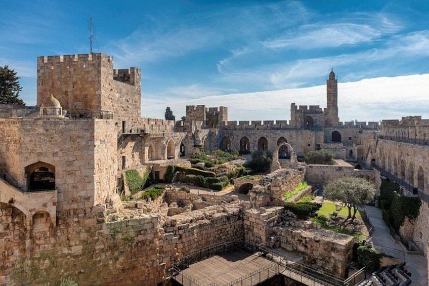 An ancient stone fortress with towers and arched walkways. 1