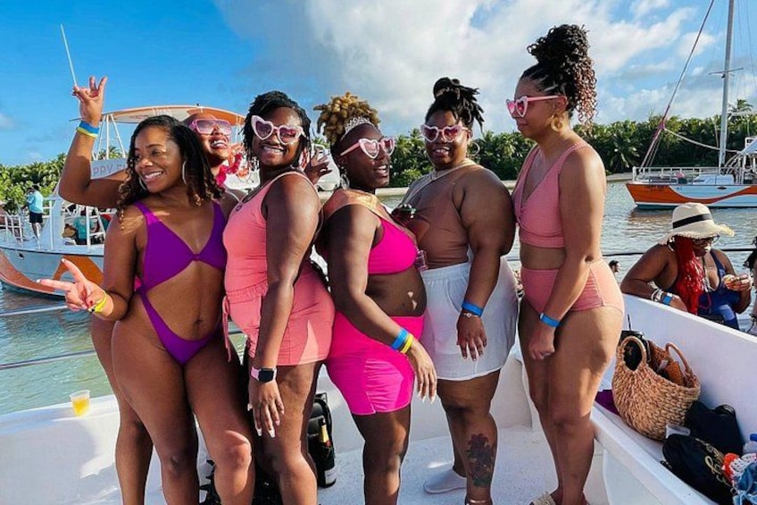 Un groupe de personnes se trouve sur un bateau, vêtues de maillots de bain, avec un ciel dégagé et une eau calme en arrière-plan. 2