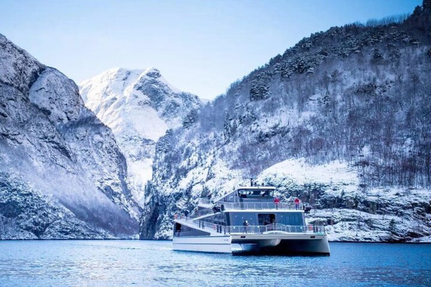 A boat on a river surrounded by snow-covered mountains. 1