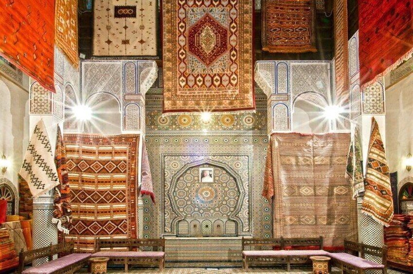 Una habitación con alfombras elaboradas, muebles de madera y diseños detallados en las paredes. 5