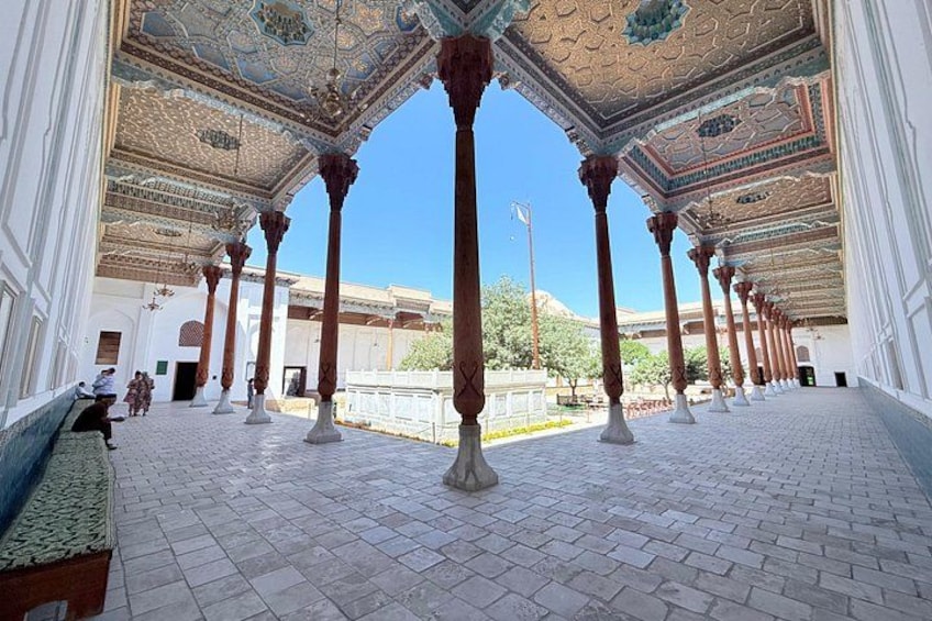 A corridor with ornate ceilings, columns, and a tiled floor. 1