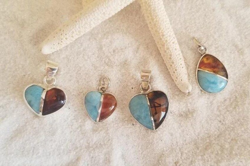 A set of heart-shaped earrings with turquoise and brown stones, displayed on a textured surface. 5