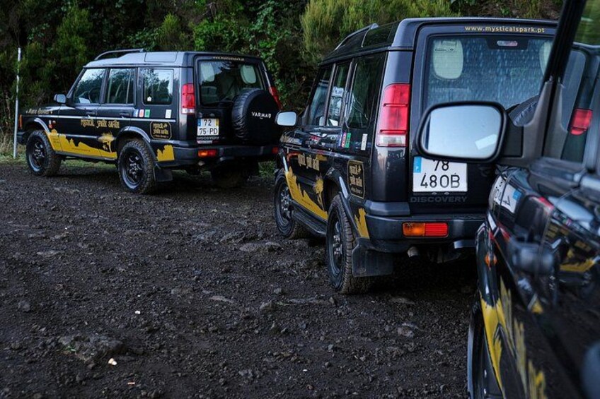 Two off-road vehicles parked on a muddy terrain. 2