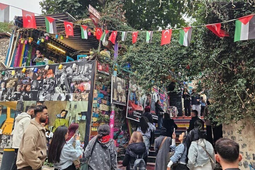 Un mercado callejero con banderas, un escenario y gente. 5