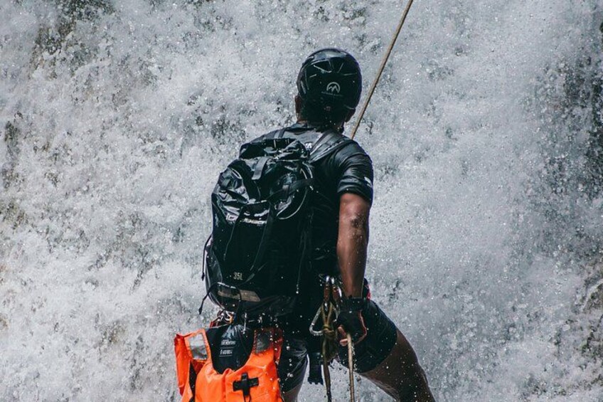 Una persona descendiendo en rappel por una cascada. 4