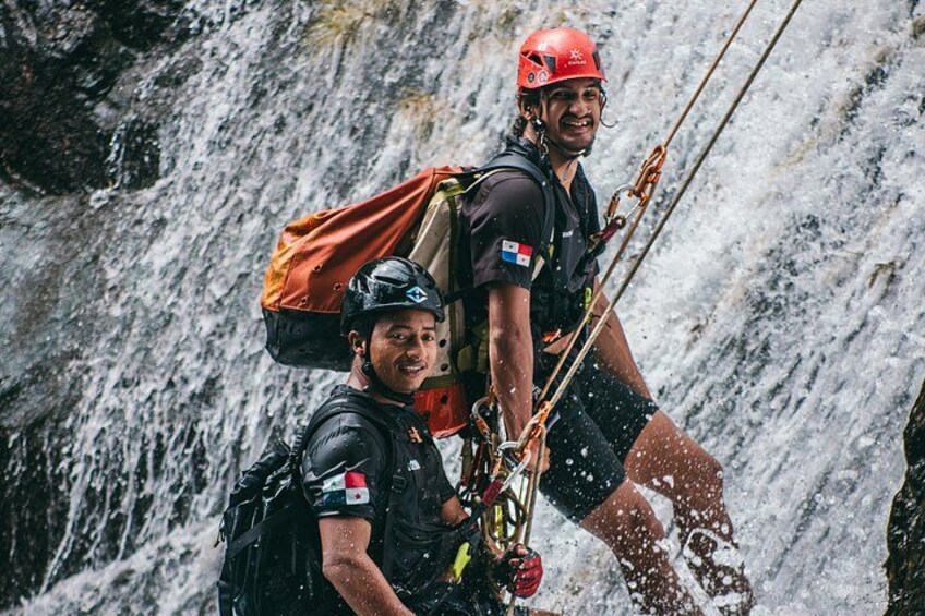 Dos personas descendiendo por una cascada con equipo de seguridad y cuerdas. 1