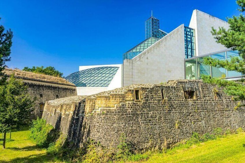 A historic stone wall with a modern building in the background. 2