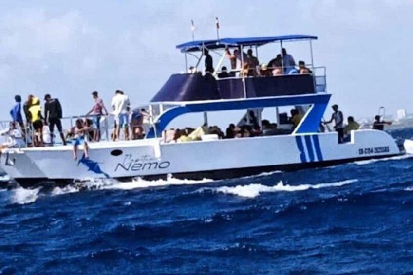 A boat named 'Nemo' with people on board, sailing on the water. 3