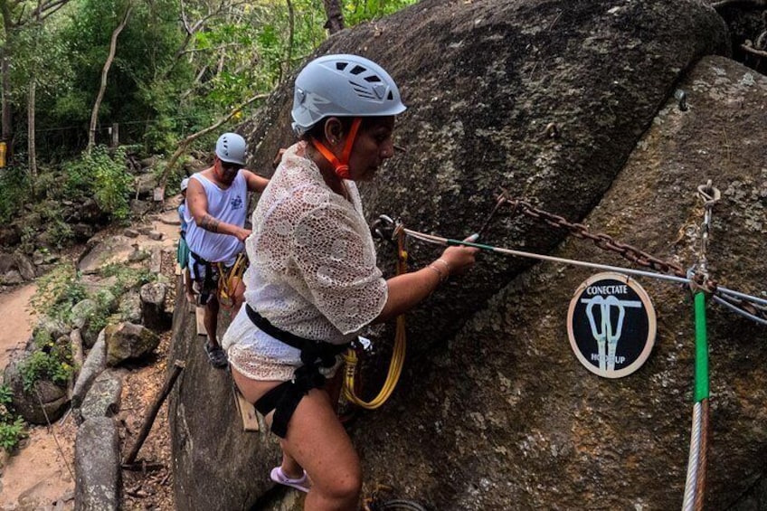A person rappelling down a rock face with safety gear and a rope. 5