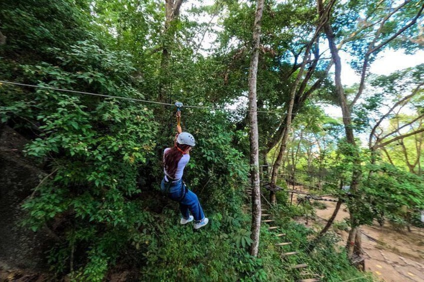 A person zip-lining through a forested area. 3