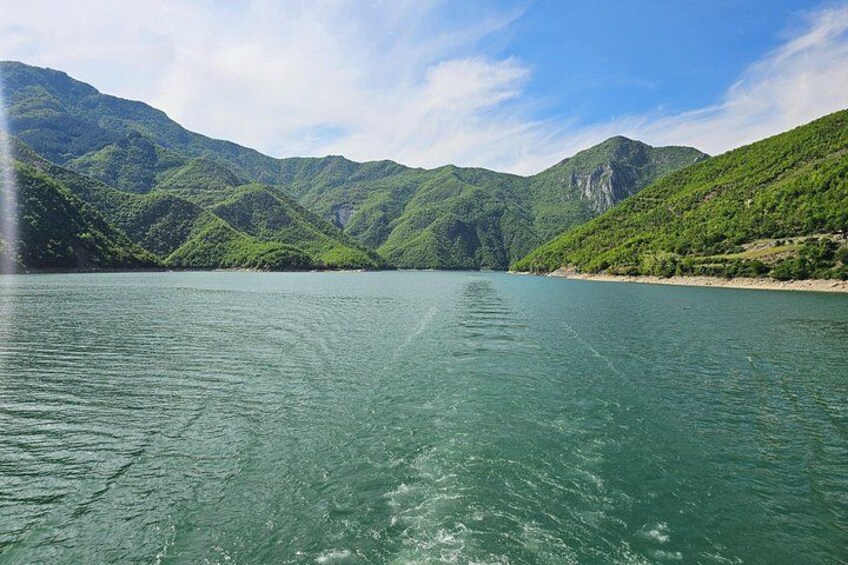 A calm lake surrounded by green hills. 2