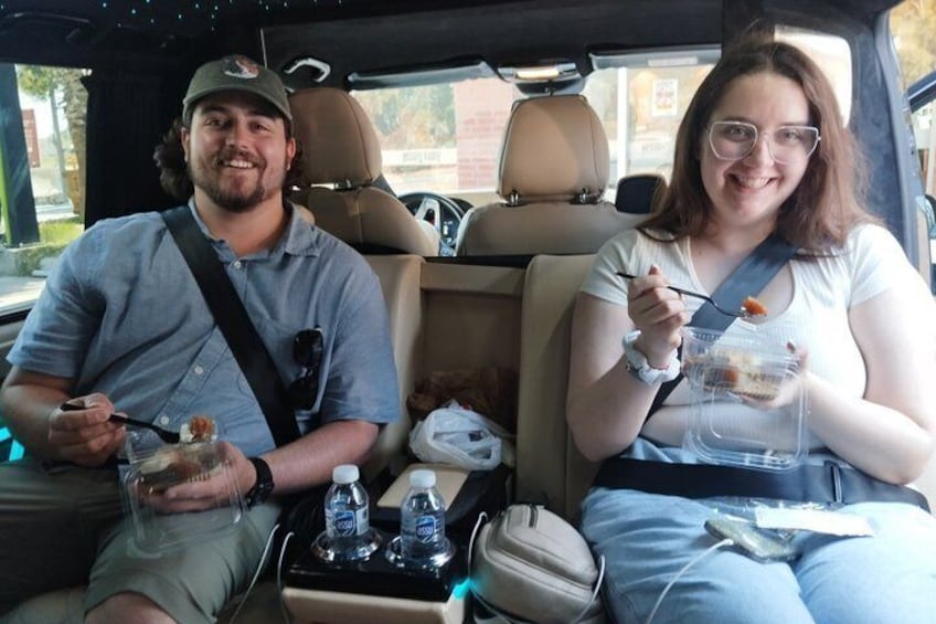 Dos personas en un coche, comiendo de recipientes. 4