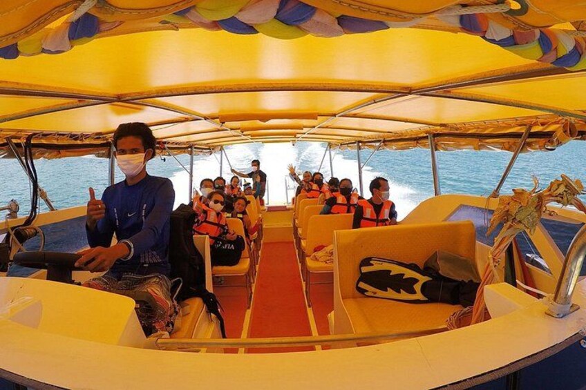 Ein Boot mit Passagieren, die Rettungswesten tragen, einem Fahrer und einer Person, die Fotos macht. 2