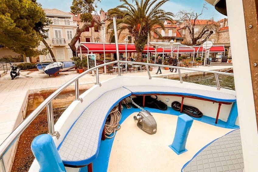 A boat docked at a marina with a red-roofed building in the background. 2