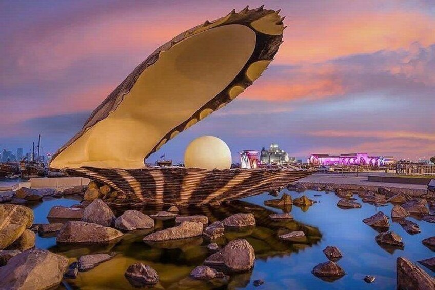 A unique architectural structure with a large, curved roof over a body of water, surrounded by rocks. 4
