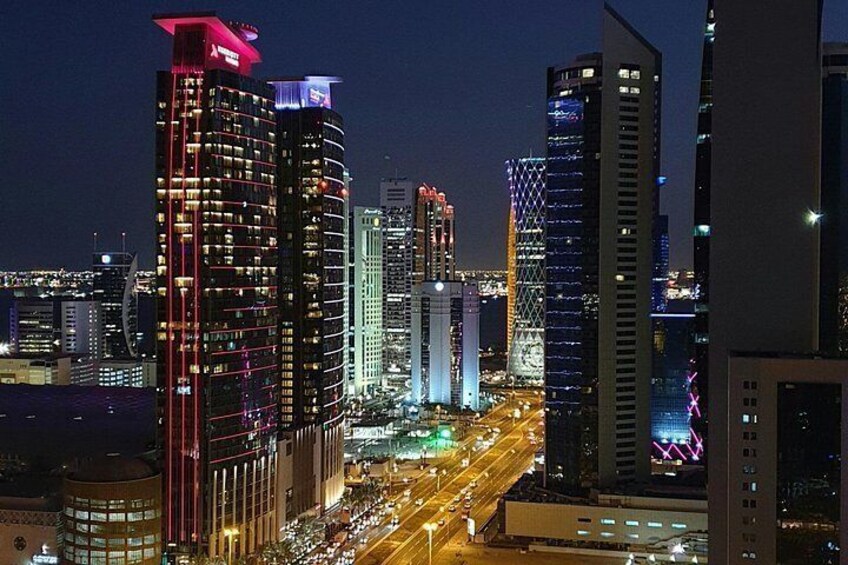 A cityscape at night with illuminated skyscrapers and a busy street. 3