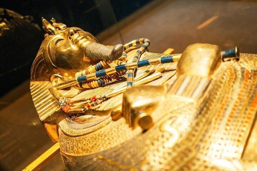 A golden sarcophagus with a cobra head, adorned with jewelry and a canopic chest. 2