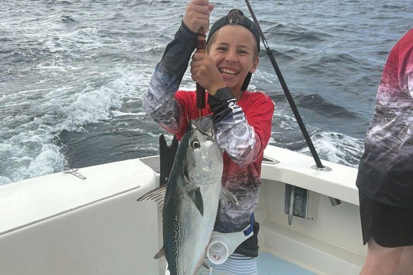 A person holding a fish on a boat. 2