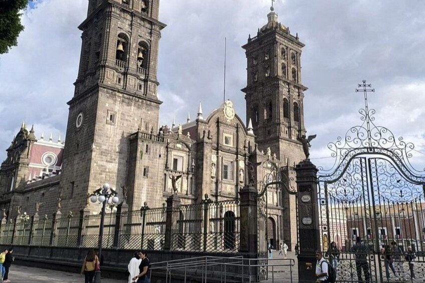 Una cattedrale storica con due alte torri e un cancello in ferro battuto. 1