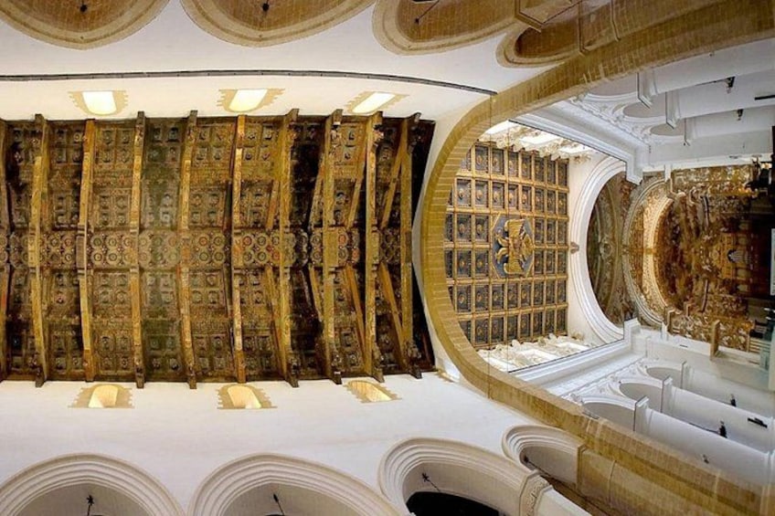 Un interior ornamentado con una pared de diseño llamativo y un ventanal circular. 1