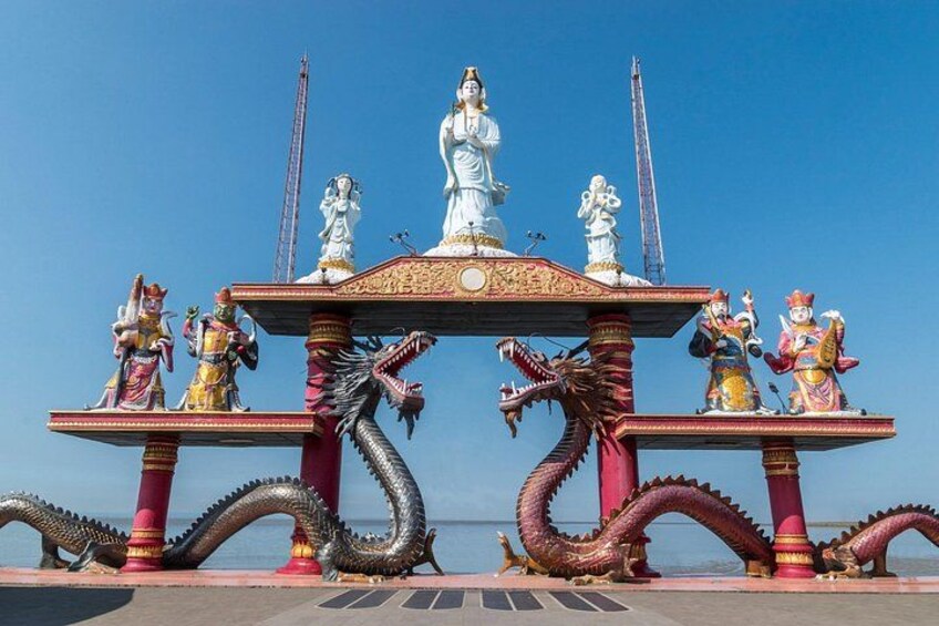 A temple with statues, dragons, and a clear blue sky. 1