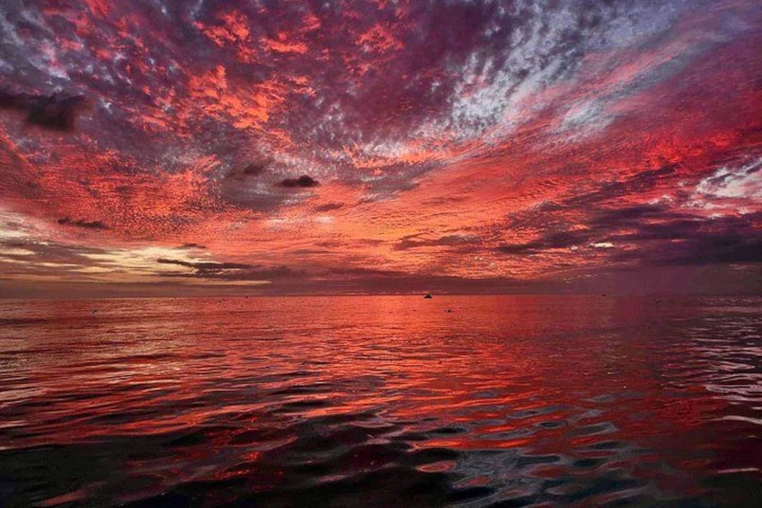 A sunset over a body of water with a vibrant sky. 5