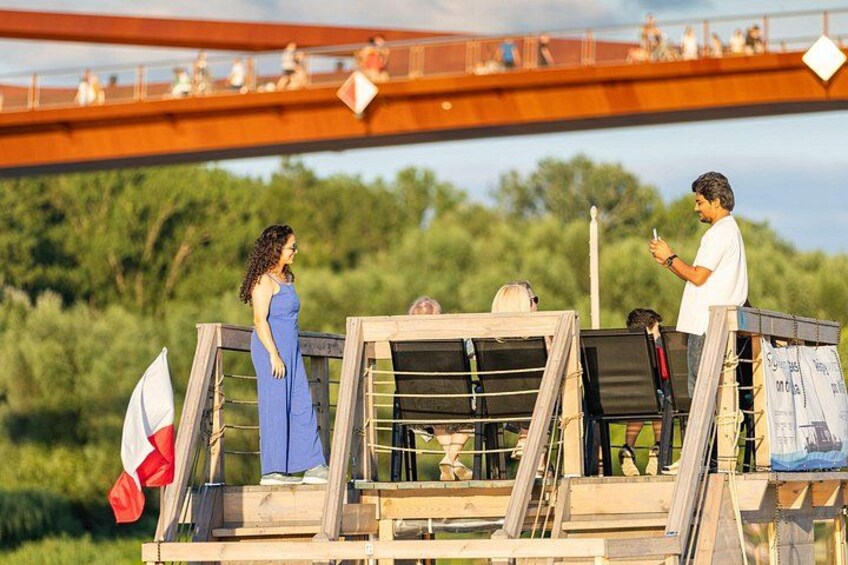 A bridge with people standing on it, a woman in a blue dress, and a man in a white shirt. 4