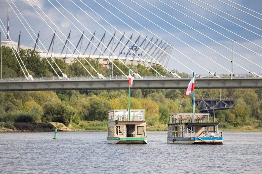 A river with two boats, a bridge, and a flag. 2