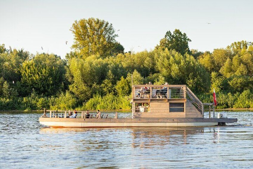 A wooden boat with a deck and seating area on a river. 5