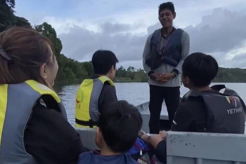 A group of people on a boat wearing life jackets, with a person standing on the dock. 2