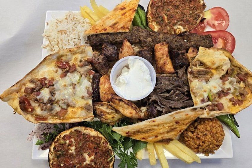 Variedad de platos de Oriente Medio, incluyendo falafel, hummus y carnes a la parrilla. 3
