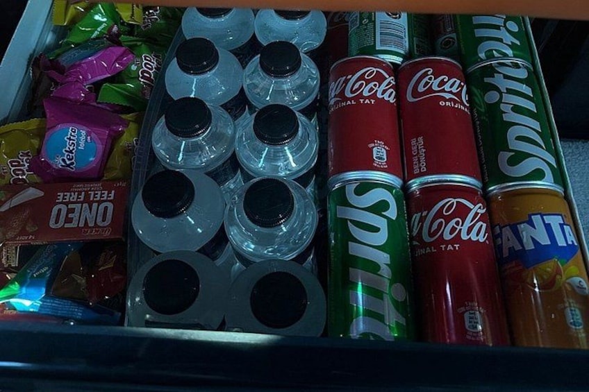 Un cajón con varias latas y botellas de bebidas, incluyendo Sprite, Coca-Cola y Fanta. 2