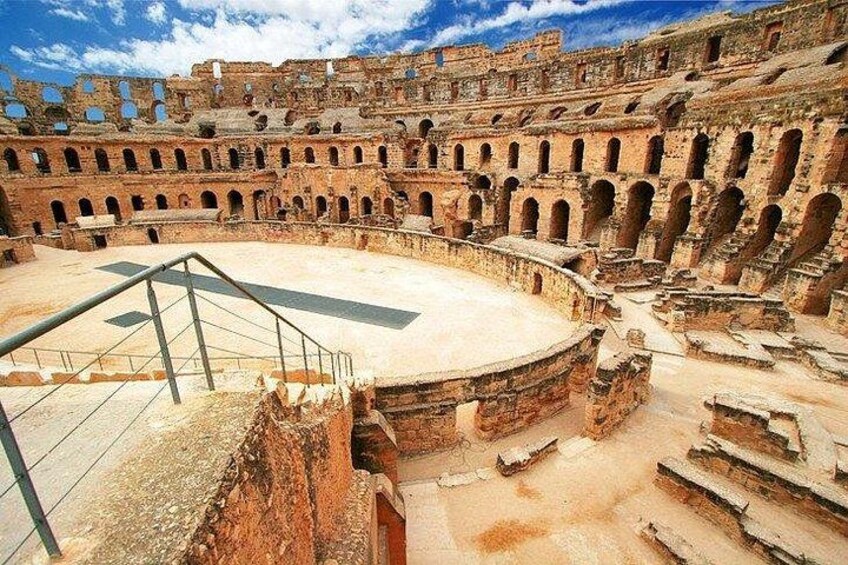An ancient amphitheater with multiple tiers of seating and a central stage. 5