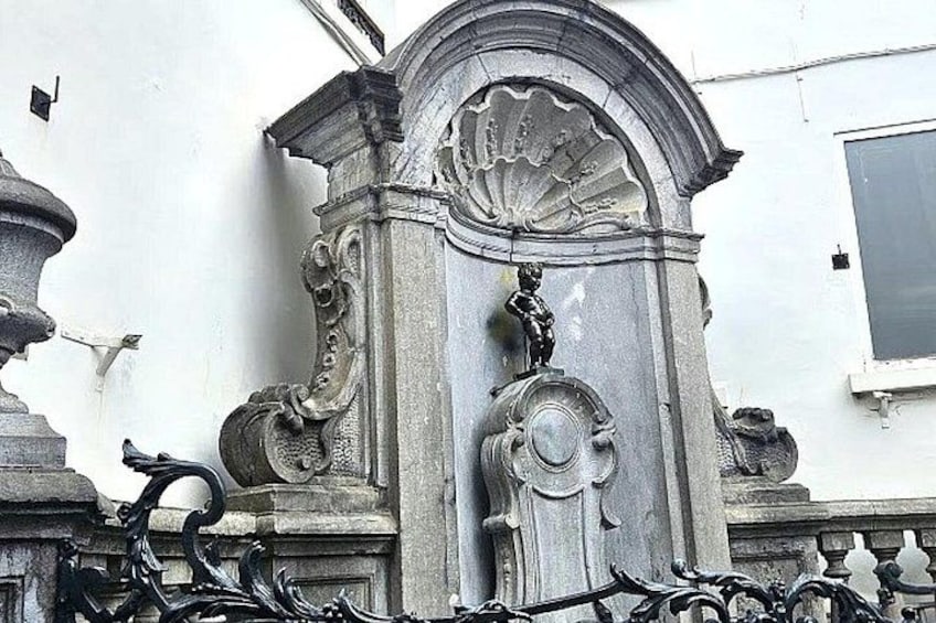 A classical architectural structure with ornate carvings and a decorative metal fence. 4