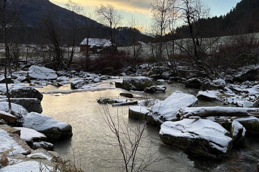 A river with snow-covered rocks and trees in a mountainous landscape. 5
