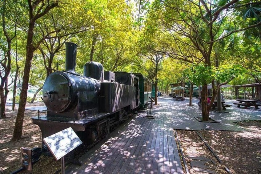 A steam locomotive on a wooden track surrounded by trees. 3
