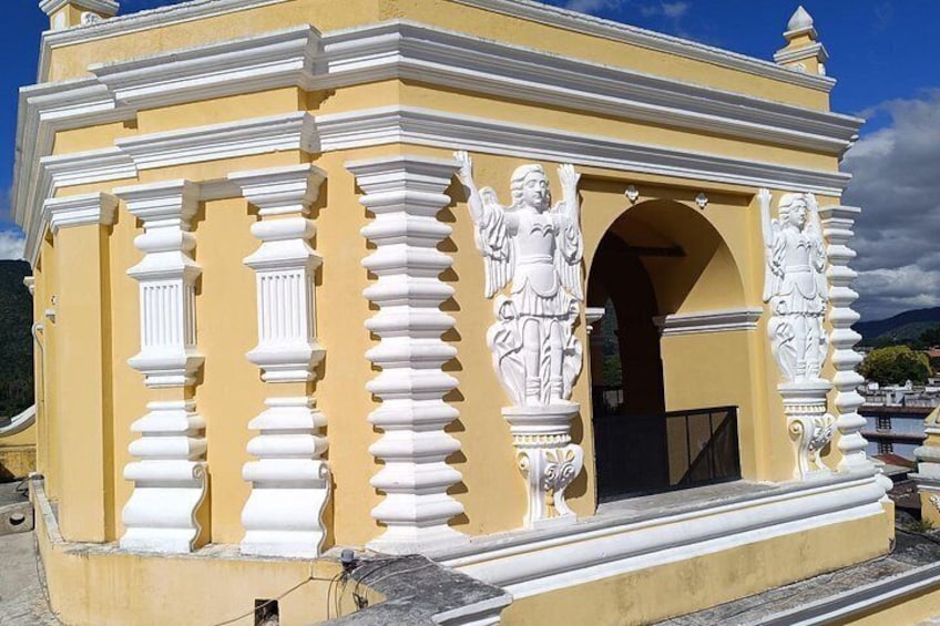 Un edificio amarillo con columnas blancas y estatuas. 4