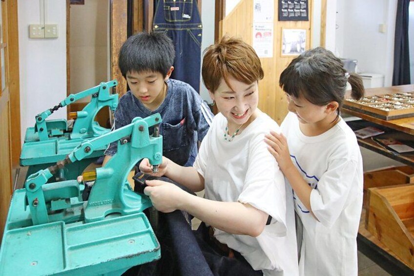 Three people working with a mechanical device in a workshop. 3