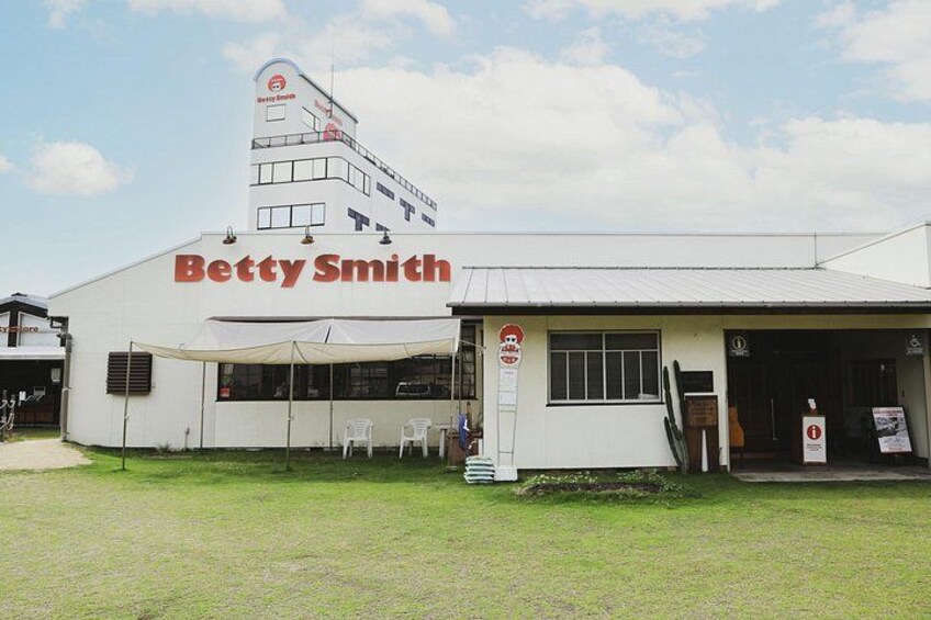 A building with the sign 'Betty Smith' and a small outdoor seating area with chairs. 2