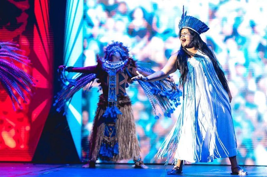 A person in a blue and white costume with a headdress, holding a fan. 2